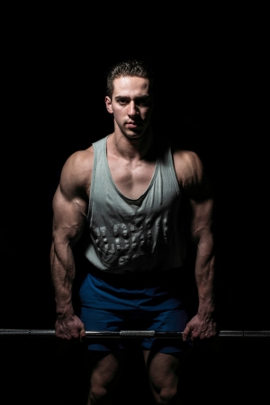 young bodybuilder posing on black backgroundの写真素材