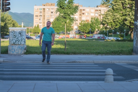 young man walking on zebra crossingの写真素材
