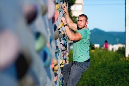 young man climbing wall rock outdoorsの写真素材