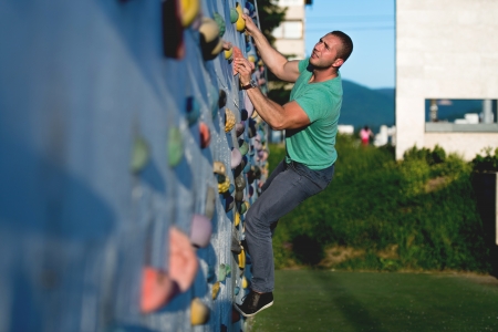 young man climbing wall rock outdoorsの写真素材