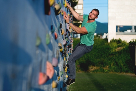 young man climbing wall rock outdoorsの写真素材