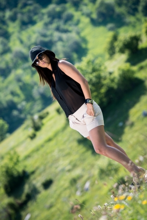 beautiful woman with hat standing on the grassの写真素材