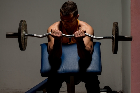 fitness trainer doing heavy weight exercise for bicepsの写真素材