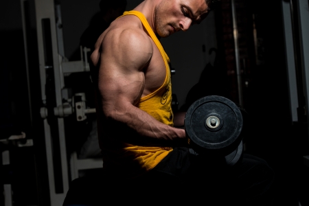 young man doing heavy weight exercise for bicepsの写真素材