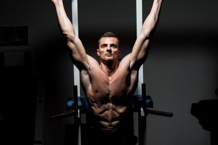 handsome man exercising his abs at the gymの写真素材