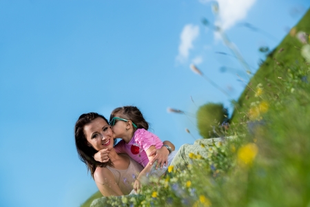 daughter kissing mother on the cheekの写真素材