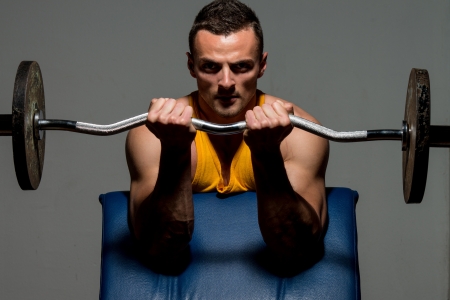 fitness trainer doing heavy weight exercise for bicepsの写真素材