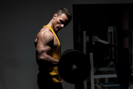 young man doing heavy weight exercise for bicepsの写真素材