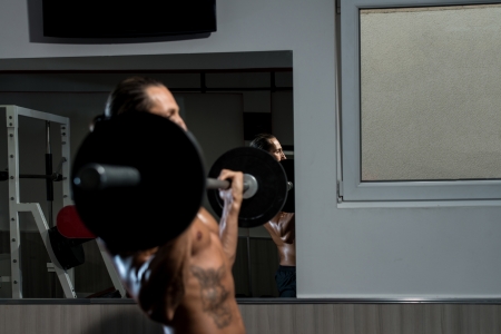 Man Lifting Barbell In Gymの写真素材