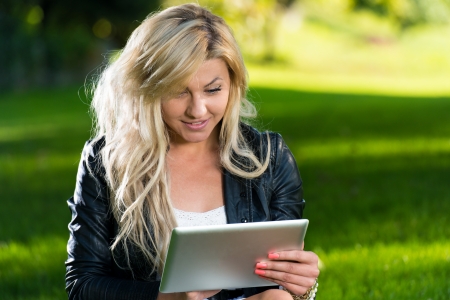 Young Woman using a digital tablet in the parkの写真素材