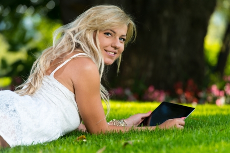 Young Woman using a digital tablet in the parkの写真素材