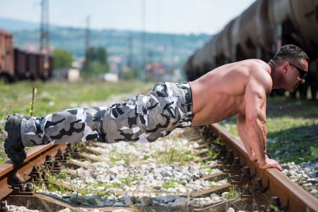 Handsome Man Doing Pushups At Railroadの写真素材