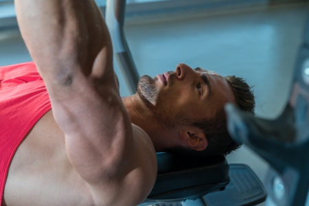 Man Lies On A Bench And Does Dumbbell Pressesの写真素材