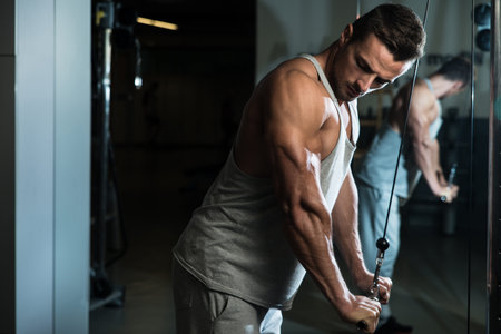 Bodybuilder Doing Heavy Weight Exercise For Triceps With Cable