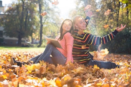 Couple Listening To Music On Autumn Leavesの写真素材