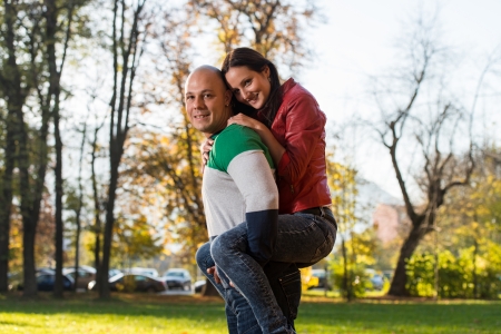 Male Carrying Smiling Female On His Back At Parkの写真素材