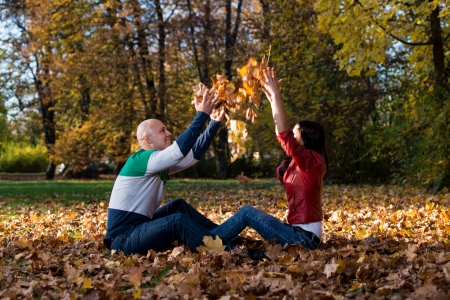 Couple Throwing Leaves In The Airの写真素材