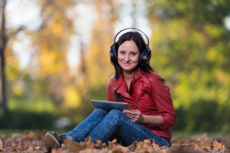 Young Girl With Headphones Enjoying Music In Autumnの写真素材