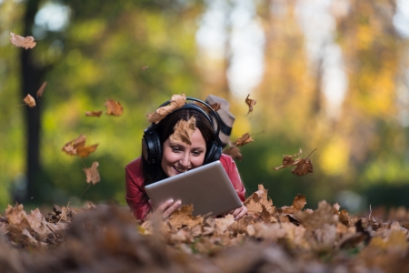 Girl Listening To Music On Autumn Leavesの写真素材