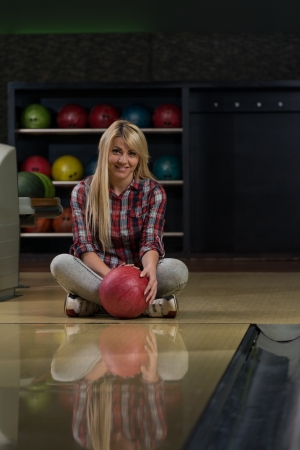 Happy Bowler Sitting At The Bowling Alleyの写真素材