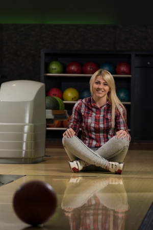 Happy Bowler Sitting At The Bowling Alleyの写真素材