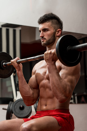 Muscular Men Doing Heavy Weight Exercise For Bicepsの写真素材
