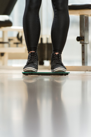 Pair Of Legs Standing On A Scaleの写真素材