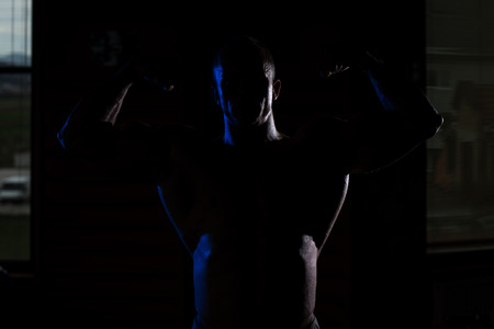 silhouette Young Muscular Man Flexing Muscles の写真素材