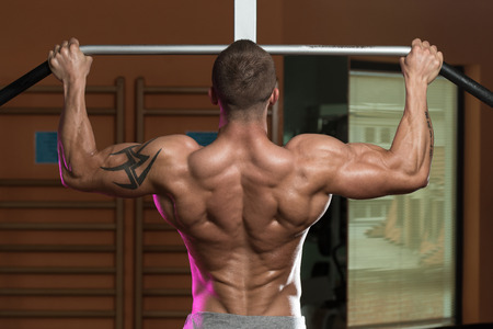 Male Athlete Doing Pull Ups - Chin-Ups In The Gymの写真素材