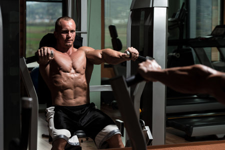 Young Man Doing Heavy Weight Exercise For Chest