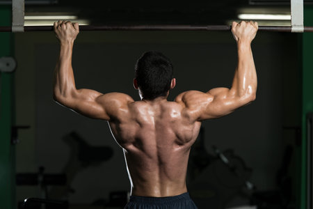 Male Athlete Doing Pull Ups - Chin Ups In The Gym