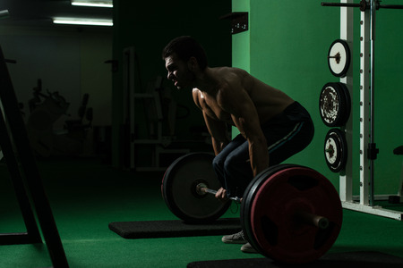 Muscular Man Lifting Dead Lift In The Gymの写真素材
