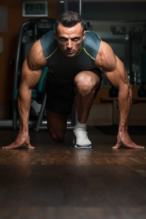 Strong Muscular Men Kneeling On The Floor - Almost Like Sprinter Starting Positionの写真素材