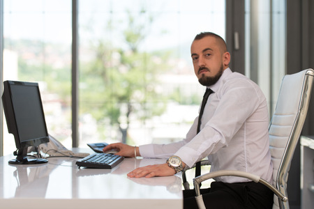 Portrait Of A Young Business Man Using A Computer In The Officeの写真素材