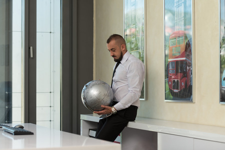 Young Businessman Holding Globeの写真素材