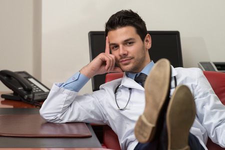 Young Doctor Relaxes Sitting In The Officeの写真素材