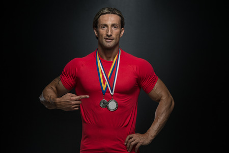 Male Fitness Competitor Showing His Winning Medalの写真素材