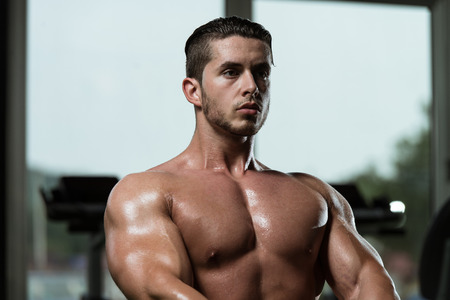 Young Bodybuilder Doing Heavy Weight Exercise For Back In Gymの写真素材