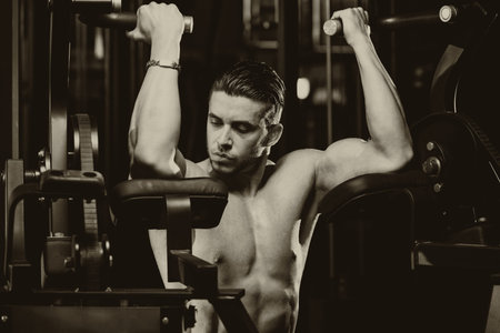 Male Bodybuilder Doing Heavy Weight Exercise For Biceps