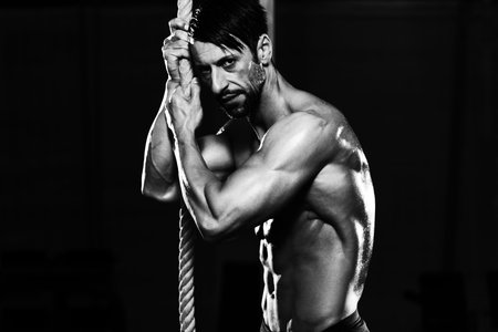 Man Resting After Fitness Rope Climb Exercise In Fitness Gym Workout