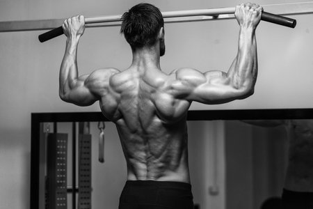 Male Fitness Athlete Doing Heavy Weight Exercise For Back