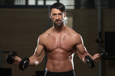 Fit Athlete Working Out Biceps - Dumbbell Concentration Curls