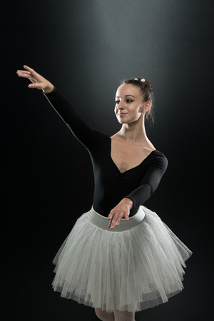 Beautiful Female Ballet Dancer On A Black Background - Ballerina Is Wearing A Tutu And Pointe Shoesの写真素材