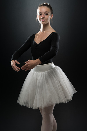 Beautiful Female Ballet Dancer On A Black Background - Ballerina Is Wearing A Tutu And Pointe Shoesの写真素材
