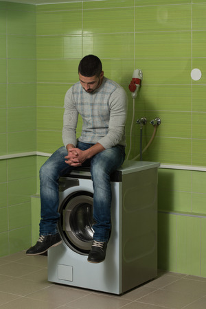 Handsome Young Man In The Laundry Roomの写真素材