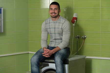 Handsome Young Man In The Laundry Roomの写真素材