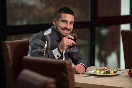 Handsome Man Eating At A Restaurant And Looking Happyの写真素材