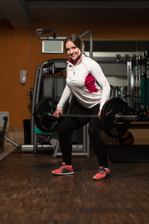 Young Woman Doing Heavy Weight Exercise For Backの写真素材