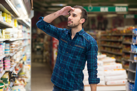 Handsome Young Man Shopping For Fruits And Vegetables In Produce Department Of A Grocery Store - Supermarket - Shallow Deep Of Fieldの写真素材
