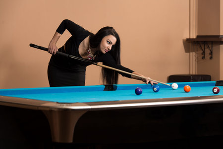 Young Woman Playing Billiards Lined Up To Shoot Easy Winning Shot